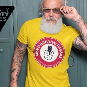 May include: Yellow t-shirt with a red circle graphic that says "Armed with that hammer" and "Legally protecting me & mine".