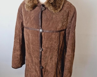 May include: A brown suede coat with a faux fur collar. The coat features a button-up front, diamond-stitched pattern, and leather trim. The coat is displayed on a wooden mannequin.