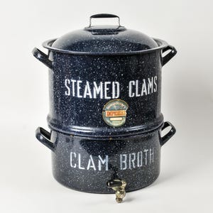 May include: A two-tiered, navy blue speckled enamelware clam steamer with a lid and handles. The top section reads "STEAMED CLAMS" and the bottom reads "CLAM BROTH" in white lettering. A spigot is visible on the bottom.