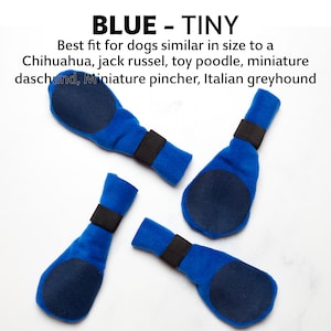 Könnte beinhalten: Vier blaue Hundestiefel mit schwarzen Gummibändern. Die Stiefel haben eine runde, blaue, rutschfeste Sohle.