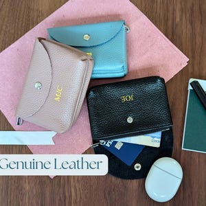 Genuine leather coin purse with zip compartment and open compartment in black, pink and blue.