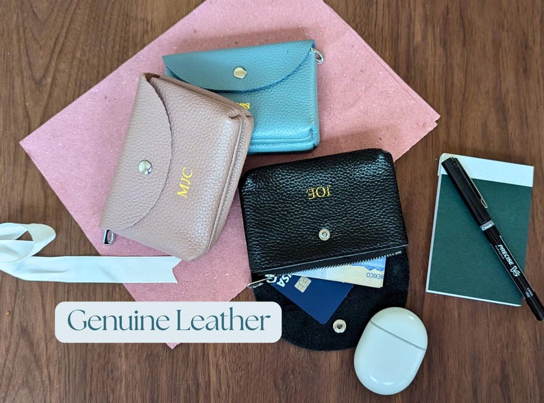 Genuine leather coin purse with zip compartment and open compartment in black, pink and blue.