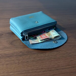 Pink, black and blue coin purses from the side tumbled over.