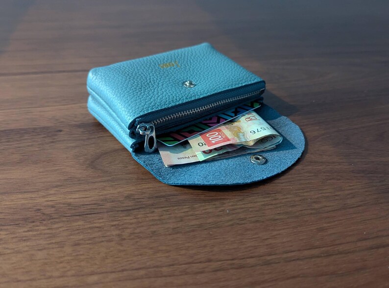 Pink, black and blue coin purses from the side tumbled over.