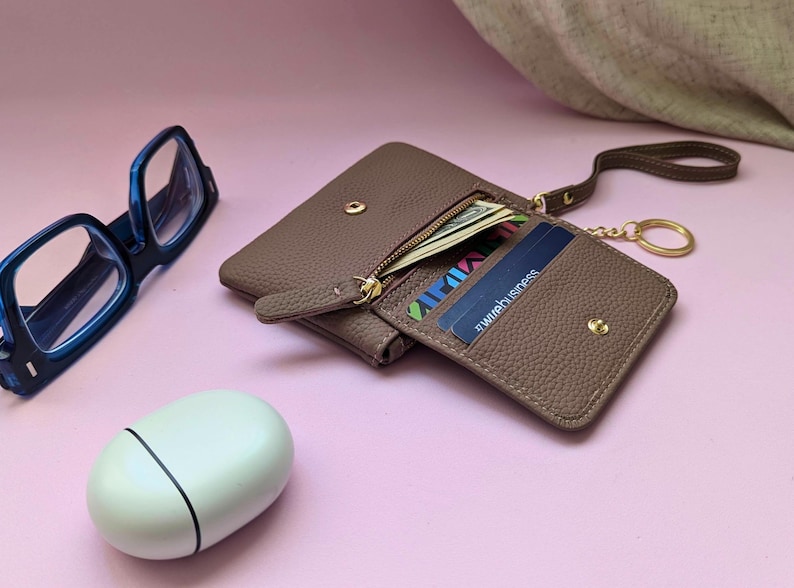 Mauve card holder with keyring, zipper purse and internal pocket in an opendisplay.