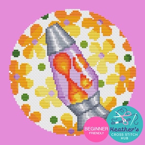 May include: A cross-stitch design featuring a lava lamp with orange and yellow accents, set against a white background with yellow flowers and green dots. The design is circular, with the text "BEGINNER FRIENDLY" and "Heather's CROSS STITCH HUB".