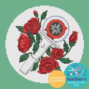 Pode incluir: Padrão de ponto cruz com rosas vermelhas, um design de bússola e uma alça branca. O design está em um fundo branco com uma borda verde. Inclui o texto "Advanced Beginner" e "Heather's Cross Stitch Hub".