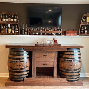whiskey barrel bar with walnit river top with a whiskey bottle buried in the river, doors on the barrels for plenty of storage inside