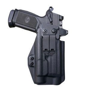 May include: A black handgun with a black holster. The holster has two clips on the side and a black screw on the bottom.