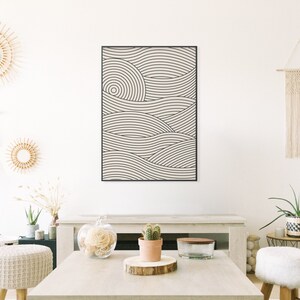 Pu&ograve; includere: Una stampa d'arte da parete astratta in bianco e nero con un motivo a onde. La stampa &egrave; incorniciata in una cornice nera e appesa a una parete bianca.
