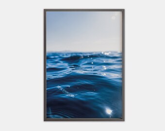 May include: A close-up photo of a blue ocean with sunlight reflecting off the water.