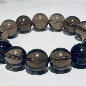 May include: A dark brown smoky quartz beaded bracelet with round beads.