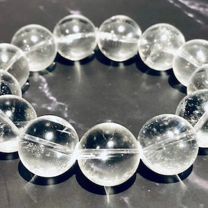 Peut inclure: Un bracelet en cristal de quartz clair avec des perles rondes. Le bracelet est fait de pierres naturelles et a une finition polie.