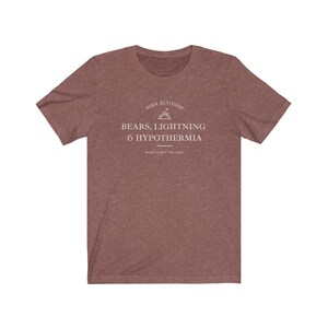 May include: A heather brown t-shirt with a white graphic design that says "High Altitude - Bears, Lightning & Hypothermia - What's not to like?"
