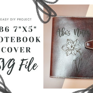 May include: A brown leather notebook cover with a white stitched border. The cover is engraved with the text "Abi's Notes" and a stylized flower design. The cover is 7 inches by 5 inches.