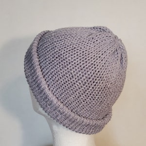 May include: A gray knitted beanie with a folded brim. The beanie is made of a soft, textured yarn.
