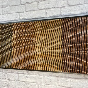 May include: A wall-mounted wooden art piece with a wavy pattern. The piece is made of different shades of wood, creating a layered effect. The wood is arranged in a repeating pattern of waves, creating a dynamic and modern look.