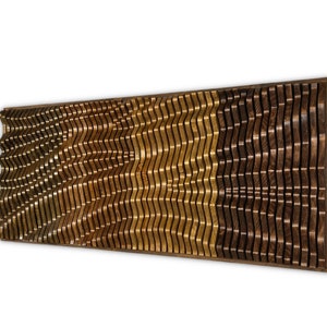 May include: A wall art piece made of wood with a wavy pattern. The wood is stained in shades of brown and gold.