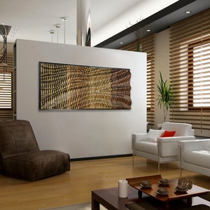 May include: A modern living room with a brown leather chair, two white couches with red pillows, and a wooden coffee table. A large abstract wall art piece with a gold and brown geometric pattern hangs on the wall.