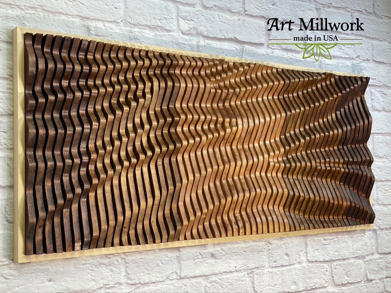 May include: A wooden wall art piece with a wavy pattern in shades of brown. The piece is framed in a light wood frame and has the text "Art Millwork - made in USA" in the top right corner.