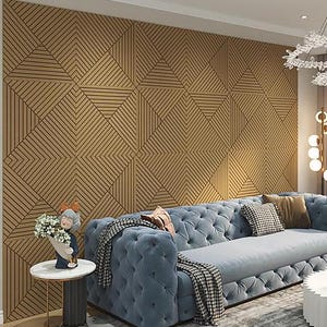 May include: A living room scene featuring a large, tufted blue sofa with decorative pillows and a patterned throw blanket. A small side table holds a figurine and flowers. The wall is covered in a geometric wood panel design.