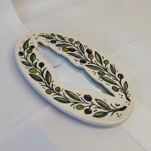 Decorative letter 'O' with green leaf pattern on a white background
