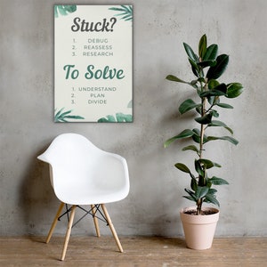 May include: A motivational canvas print with the text "Stuck?" followed by steps to debug, reassess, and research. Below, "To Solve" lists steps to understand, plan, and divide. The print is decorated with green leaf accents.