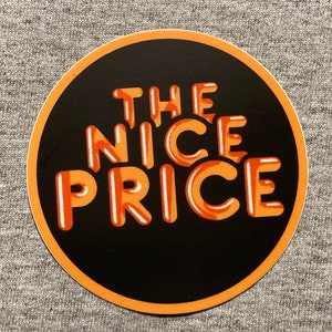 May include: A black and orange round sticker with the text "THE NICE PRICE" in a stylized font.