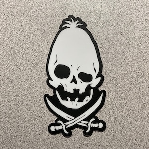May include: A black and white sticker featuring a skull with crossed swords. The skull has large eye sockets and a detailed jawline. The design is outlined in black, with a white skull and crossed swords.