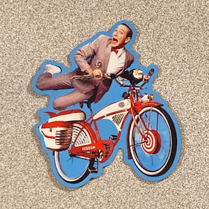 May include: A die-cut sticker featuring a person in a grey suit and red bow tie riding a vintage-style red and white bicycle. The person has an expressive, surprised facial expression while leaning forward on the handlebars of the bicycle.
