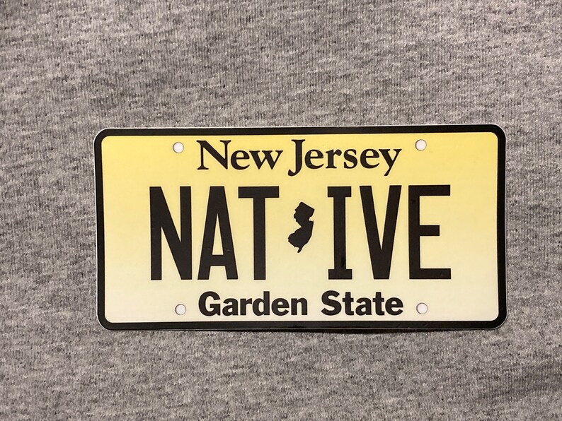 Pu&ograve; includere: Targa gialla con testo nero. In alto si legge "New Jersey", al centro "NATIVE" con la sagoma del New Jersey e in basso "Garden State".