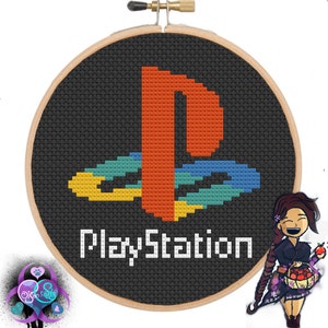 Puede incluir: Un aro de bordado de punto de cruz negro y blanco con el logotipo de PlayStation y el texto "PlayStation" en blanco.