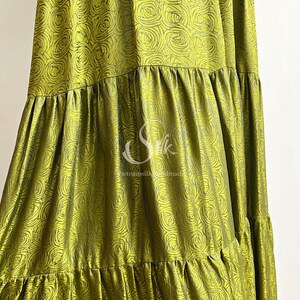 May include: A green silk skirt with a floral pattern. The skirt has multiple tiers and is made in Vietnam.