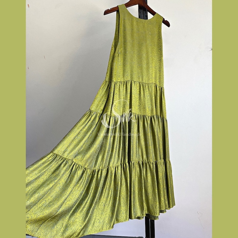 May include: A sleeveless, tiered maxi dress in a bright green color with a subtle pattern. The dress has a relaxed fit and a flowy silhouette.