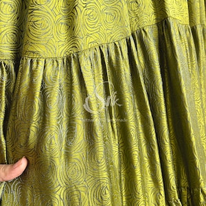 May include: A green silk skirt with a rose pattern. The skirt has a gathered waist and a tiered design.