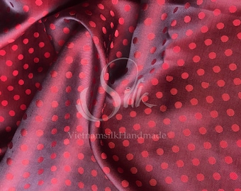 May include: Red silk fabric with a polka dot pattern. The fabric is draped and has a subtle sheen. The text "VietnamsilkHandmade" is visible in the lower center of the image.