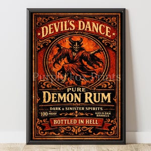 May include: Framed print featuring a vintage advertisement for "Devil's Dance" rum. The artwork depicts a horned demon in a red robe, with text reading "Pure Demon Rum" and "Bottled in Hell." The color palette includes red, orange, and black.