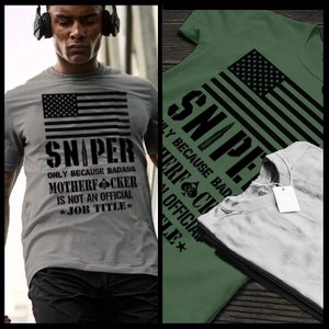 May include: Gray t-shirt with a black American flag graphic and the word "SNIPER" above the text "ONLY BECAUSE BADASS MOTHERFUCKER IS NOT AN OFFICIAL JOB TITLE". A green t-shirt with the same design is also shown.