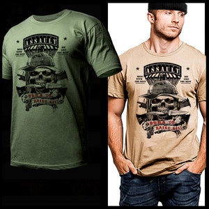 May include: A green and tan t-shirt with a skull graphic and the text "ASSAULT" and "BORN TO RAISE HELL".