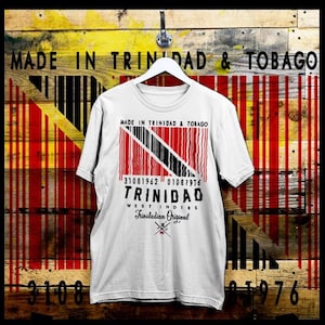 Puede incluir: Camiseta blanca con un diseño de código de barras negro y rojo que presenta la bandera de Trinidad y Tobago. El texto "MADE IN TRINIDAD & TOBAGO", "31081962 01087976", "TRINIDAD", "WEST INDIES" y "Trinidadian Original" está impreso en la camiseta.