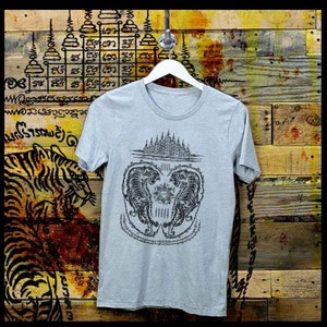 May include: A heather grey t-shirt with a black and white graphic print of two tigers facing each other. The graphic includes a design of a temple and Thai script.