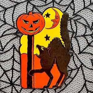 May include: A vintage Halloween decoration featuring a jack-o'-lantern, a crescent moon with a face, and a howling black cat. The figures are set against a yellow and orange background, with a black spiderweb lace backdrop.