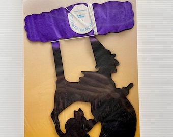May include: A packaged Witch Garland decoration. The package features a purple witch silhouette with a cat, a purple garland, and the text "Witch Garland". The background is yellow and the packaging is clear plastic.