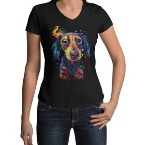 May include: A black v-neck t-shirt with a colorful watercolor illustration of a dachshund dog. The dog is looking at the viewer with a playful expression.