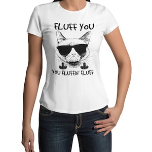 Può includere: T-shirt bianca con grafica nera di un gatto con occhiali da sole e la scritta "FLUFF YOU YOU FLUFFIN' FLUFF". La grafica del gatto è in stile disegno a tratto.