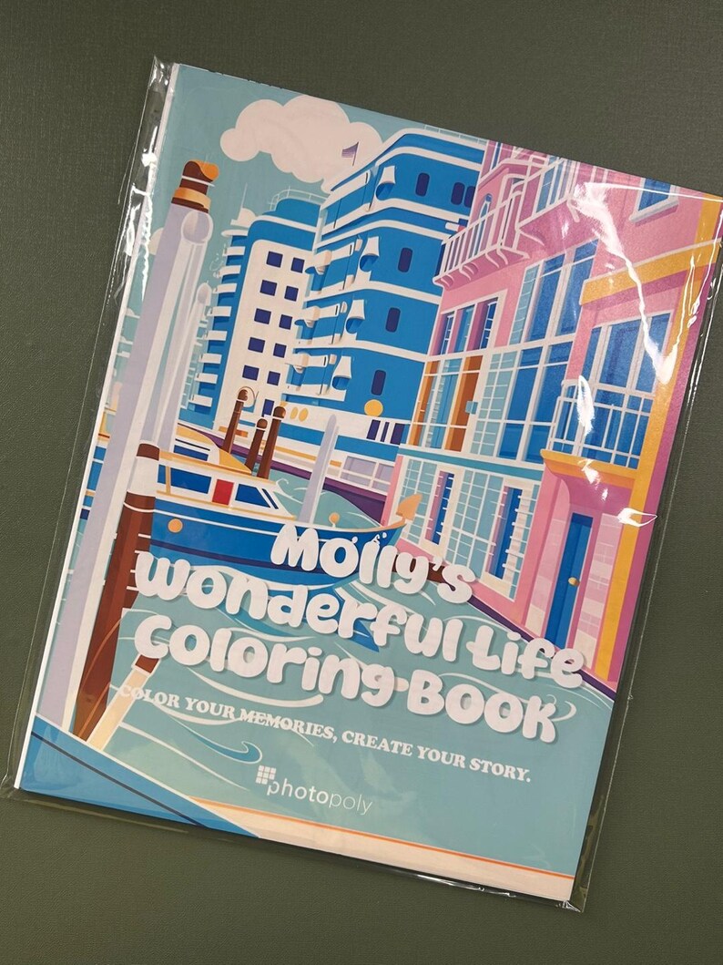 Może przedstawiać: Kolorowa książka do kolorowania z tytułem "Molly's Wonderful Life Coloring Book" i hasłem "Koloruj swoje wspomnienia, stw&oacute;rz swoją historię." Okładka przedstawia ilustrację kanału z budynkami po obu stronach i łodzią w wodzie.