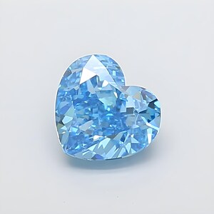 Puede incluir: Una piedra preciosa en forma de corazón con talla brillante, que presenta un color azul claro vibrante y numerosas facetas que reflejan la luz para crear un aspecto brillante. La piedra tiene una silueta de corazón simétrica con una base.
