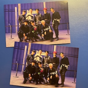 Puede incluir: Dos fotos de un grupo de 10 jóvenes que visten ropa negra y blanca con diseños gráficos. Los hombres están de pie en fila frente a una pared gris con una barandilla de metal. Los hombres están mirando todos a la cámara. Las fotos están tomadas desde un ángulo ligeramente elevado.