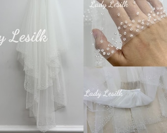 May include: A single-tier white bridal veil with a beaded edge. The veil is made of soft tulle and features a comb for easy attachment.