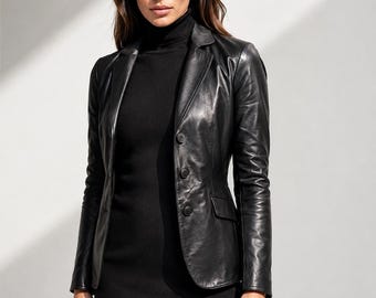 Könnte beinhalten: Ein schwarzer Lederblazer mit steigendem Revers, langen Ärmeln und einer Knopfleiste mit drei Knöpfen. Die Jacke verfügt über zwei seitliche Pattentaschen und wird über einem schwarzen Rollkragenpullover getragen, was für einen strukturierten Look sorgt.